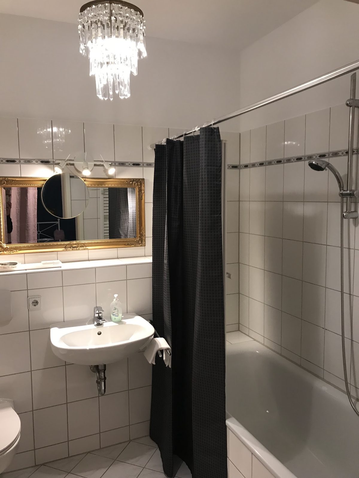 Badezimmer mit goldgerahmtem Spiegel und Wanne