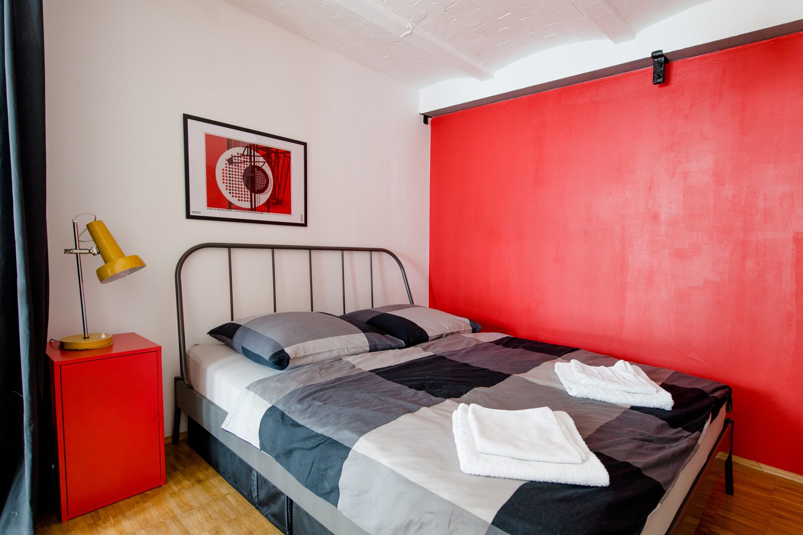 Schlafzimmer mit rotem Nachtschrank und gelber Lampe